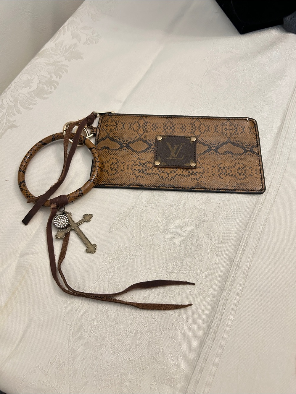 A re-designed LV logo on a Brown Snake-Print Key Ring Wristlet